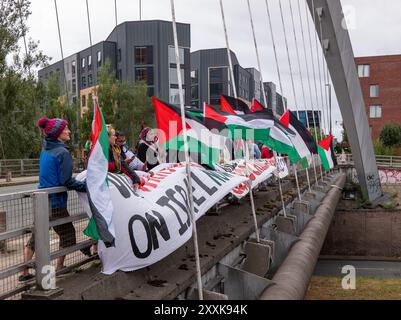 Manchester, Großbritannien. August 2024. Palästinensische Demonstranten besetzen die Straßenbrücke über die befahrene Princess Road (A5103), eine Hauptstraße, die nach Manchester führt. Um 12.00 Uhr wurden auf beiden Seiten der Brücke, die für den Hulme-Bogen berühmt ist, Banner ausgeklappt, was dazu führte, dass die Polizei eine der Fahrbahnen der Duellstraße blockierte und sich Verkehr aufbaute. Die Straße wird aufgrund des Feiertags-Wochenendes und des Manchester Pride 2024 Festivals im Stadtzentrum besonders stark frequentiert sein. Quelle: GaryRobertsphotography/Alamy Live News Stockfoto