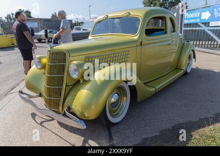 Rayleigh, Großbritannien. August 2024. Ein speziell angestrichenes, gelb-grünes Ford Coupé aus den 1930er Jahren mit Whitewall-Reifen und Chromdetails, das in der Nähe von Phoenix Motor Centre Ltd in Essex geparkt wurde. Die Konstruktion im Hot-Rod-Stil zeichnet sich durch eine abgesenkte Optik und eine glänzende Oberfläche aus, die die britische Fahrzeugkultur und den Erhalt von Oldtimern widerspiegelt. Amerikanisches Auto und Truck treffen sich in der Farm Fresh Garage. Bei der Veranstaltung können die Besitzer ihre Fahrzeuge mitbringen, damit die Besucher einen Blick aus der Nähe werfen können. Penelope Barritt/Alamy Live News Stockfoto