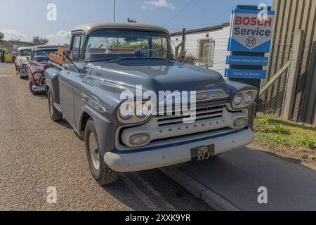 Rayleigh, Großbritannien. August 2024. Ein Chevrolet-Pickup in zweifarbiger grauer Farbe steht in der Nähe eines Bosch-Service-Centers in Großbritannien. Der Lkw verfügt über ein klassisches Design und ein sichtbares „CHEVROLET“-Emblem im Kühlergrill. Andere Oldtimer stehen dahinter, was auf eine Autoshow oder ein Oldtimer-Treffen hindeutet. Amerikanisches Auto und Truck treffen sich in der Farm Fresh Garage. Bei der Veranstaltung können die Besitzer ihre Fahrzeuge mitbringen, damit die Besucher einen Blick aus der Nähe werfen können. Penelope Barritt/Alamy Live News Stockfoto