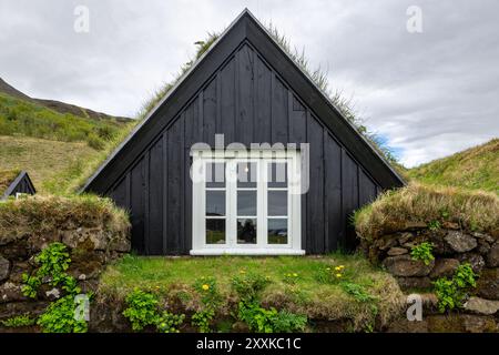 Traditionelles Rasenhaus im Skogar Open Air Museum, Wohngebäude mit schwarzer Holzfassade mit Dach mit Rasen und Moos, Island. Stockfoto