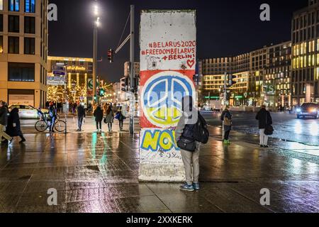 Belin, Deutschland - 20. Dezember 2022: Friedliches Symbol in ukrainischen Flaggenfarben auf einer zerbrochenen Berliner Mauer im Zentrum Berlins, Potsdamer Platz. Stockfoto