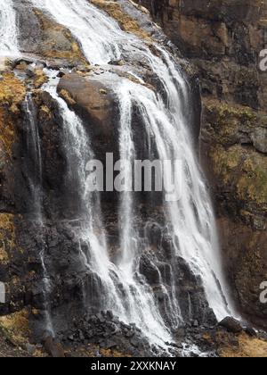 Ein atemberaubender Blick auf einen majestätischen Wasserfall, der eine zerklüftete felsige Klippe hinunterstürzt und eine wunderschöne und ruhige Naturszene schafft, die die Kraft und unterstreicht Stockfoto