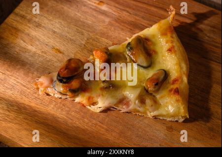 Köstliche mediterrane Meeresfrüchte-Pizza mit Jakobsmuscheln, Garnelen und Muscheln, serviert auf Holz. Italienische Küche, Stockfoto