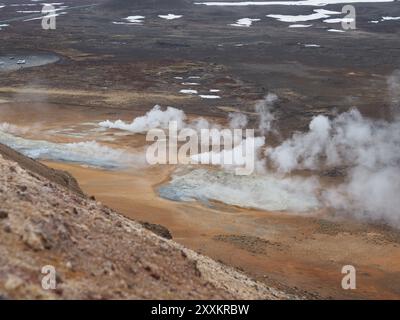 Eine beeindruckende Darstellung von geothermischem Dampf, der aus der zerklüfteten und farbenfrohen vulkanischen Landschaft strömt, zeigt die rohe Kraft und Schönheit des Erdgeanders Stockfoto