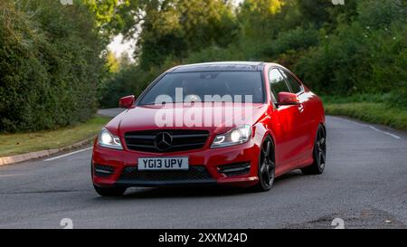 Whittlebury, Northants., Großbritannien - 25. August 2024: 2013 roter Mercedes Benz C250 amg Sportwagen auf einer britischen Landstraße. Stockfoto