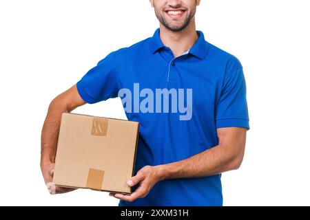 Ihr Paket ist in sicheren Händen. Zugeschnittenes Bild eines jungen Kuriers, der einen Karton hält und vor weißem Hintergrund lächelt Stockfoto