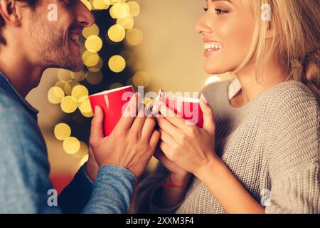 Niedliches Paar, das heissen Tee am Weihnachtsabend genießt Stockfoto