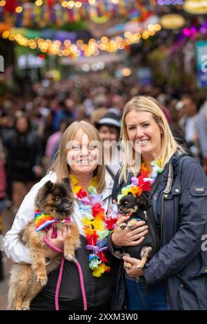 Manchester, Großbritannien. August 2024. L-R Rachel und Laura aus Chorley, Lancashire mit ihren Hunden Princess und King, Canal Street. Manchester Pride 2024 . Das diesjährige Thema lautet "Buzzin to be Queer - A Hive of Progress". Das Symbol der Manchester Bee führte die Parade an. Die Headline-Auftritte stammen von Jessie J, Loreen, Sugababes, Rita ora und dem größten Showman-Star Keala Settle. Manchester UK. Quelle: GaryRobertsphotography/Alamy Live News Stockfoto