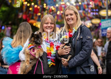 Manchester, Großbritannien. August 2024. L-R Rachel und Laura aus Chorley, Lancashire mit ihren Hunden Princess und King, Canal Street. Manchester Pride 2024 . Das diesjährige Thema lautet "Buzzin to be Queer - A Hive of Progress". Das Symbol der Manchester Bee führte die Parade an. Die Headline-Auftritte stammen von Jessie J, Loreen, Sugababes, Rita ora und dem größten Showman-Star Keala Settle. Manchester UK. Quelle: GaryRobertsphotography/Alamy Live News Stockfoto