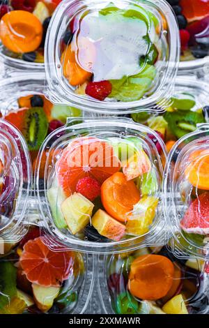 Plastikboxen mit vorverpackten Obstsalaten, in einem handelsüblichen Kühlschrank zum Verkauf aufgemacht Stockfoto