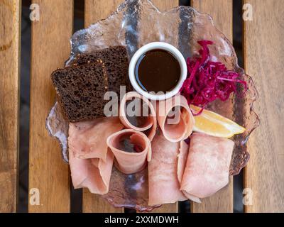 Stroganina gefrorener Fisch auf Teller auf Holztisch in einem lokalen Outdoor-Café in der Stadt Zelenogradsk in der Oblast Kaliningrad, Russland Stockfoto