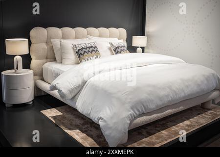 Stilvolles Schlafzimmer mit Doppelbett. Moderne Schlafzimmereinrichtung mit einem Hauptbett mit zwei Nachttischlampen. Großes, komfortables Doppelbett in eleganter Atmosphäre Stockfoto