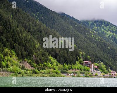 Uzungol, Türkei - 4. Mai 2024: Mehrfamilienhäuser im Dorf Uzungol an der Küste des Usungol-Sees in grün bewachsenen Bergen im Stadtteil Caykara von Tra Stockfoto
