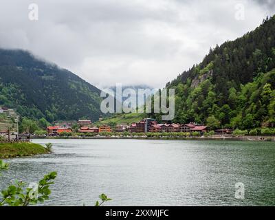Uzungol, Türkei - 4. Mai 2024: Häuser des Dorfes Uzungol an der Küste des Usungol Sees in grünen bewachsenen Bergen im Bezirk Caykara der Provinz Trabzon Stockfoto