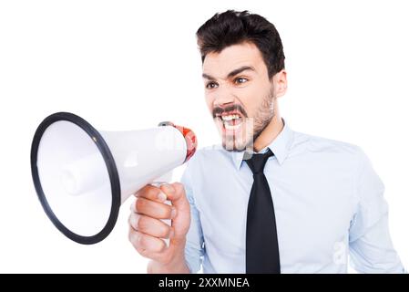Hör mir zu! Wütender junger Mann in Hemd und Krawatte, der Megaphon hält und vor weißem Hintergrund brüllt Stockfoto