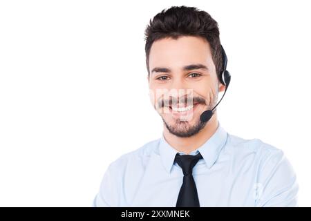 Selbstbewusster männlicher Fahrer. Porträt eines gutaussehenden jungen männlichen Bedieners im Headset, der auf die Kamera blickt und lächelt, während er vor weißem Hintergrund steht Stockfoto