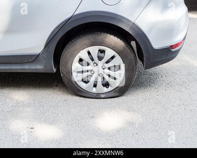 Moskau, Russland - 8. Juni 2024: Flacher Hinterreifen des Autos auf der Straße am Sommertag Stockfoto