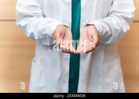 Ein Arzt zeigt seine Hände als ein Konzept der Gesundheit und Heilung von Menschen. Die Hände des Arztes in einer einladenden Geste, Empathie gegenüber dem Patienten und der Gesundheit Stockfoto