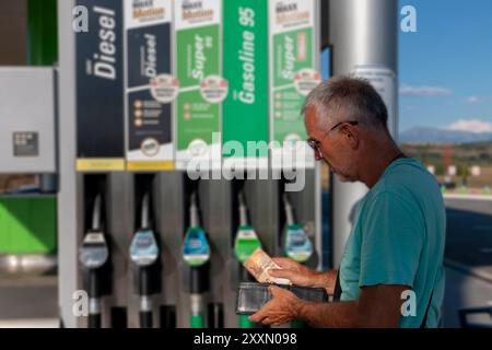 Reifer Mann, der sich Sorgen macht und Geld zählt und Euro-Banknoten hält, um hohe Benzinpreise zu zahlen. Mangel an Geld für Benzin und Kraftstoff. Teures Benzin. Stockfoto