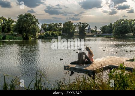 Das russische Paar auf dem hölzernen Pier am Ufer von Belgorod, am Ufer des Flusses Vezelka, in der Oblast Belgorod, Russland. Stockfoto