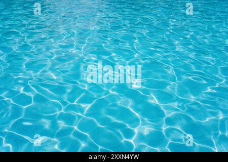 Klares blaues Poolwasser, das im Sonnenlicht schimmert. Stockfoto