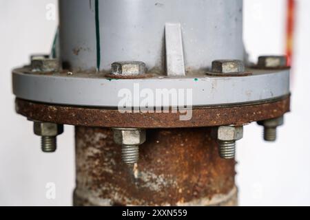 Nahaufnahme einer rostigen Flanschverbindung mit Schrauben in industrieller Umgebung. Stockfoto