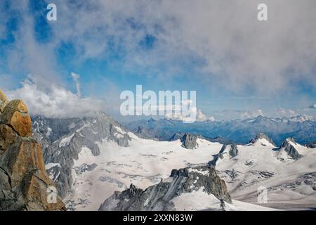 Dramatische Alpenlandschaft mit schneebedeckten Gipfeln, steilen felsigen Hängen und Wolken, die über die Hochgebirge treiben. Stockfoto
