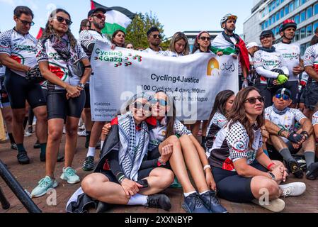 25. August 2024, den Haag (den Haag, Südholland, Niederlande: Radfahrer sitzen, hören den Sprechern zu und umarmen sich, nachdem sie ihr Ziel in den Haag erreicht haben. Am 25. August 2024 trafen 100 Radfahrer, die an Cycling 4 Gaza teilnahmen, im Gebäude des Internationalen Gerichtshofs in den Haag ein. Die Radfahrer aus 28 verschiedenen Ländern unternahmen in vier Tagen eine 300 km lange Tour von Gent in Belgien nach den Haag in den Niederlanden. Im 14. Jahr der Veranstaltung wurden mehr als 600.000 Â zur Unterstützung der psychischen Gesundheit und des Wohlbefindens von Kindern in Gaza gesammelt. (Foto: © James Petermeier/ZUMA Press Wire) EDITORIAL U Stockfoto