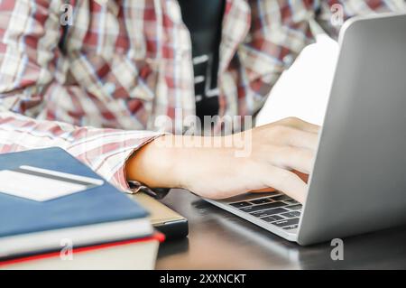 Männliche Hände arbeiten mit einem Laptop auf dem Tisch zu Hause arbeiten Stockfoto
