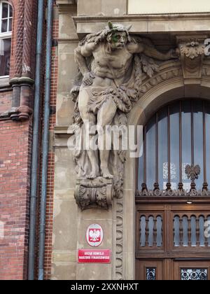 Danzig, Polen - 13. Juli 2024: Eine majestätische Skulptur des Herkules mit grünen Details unterstützt die kunstvolle Fassade eines großen Gebäudes in Danzig, Showcasi Stockfoto