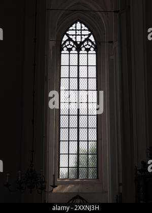 Danzig, Polen - 13. Juli 2024: Ein hohes gotisches Fenster mit komplizierten Glasmustern in einer Kirche, das die detailreiche Handwerkskunst und das Design zeigt Stockfoto