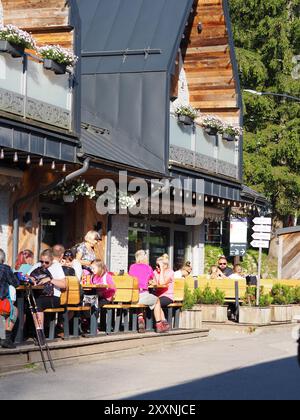 Kasprowy Wierch, Polen - 27. Juli 2024: Ein Café im Freien, in dem mehrere Leute sonniges Wetter genießen, während sie an Tischen sitzen und ihre Mutter gefangen nehmen Stockfoto