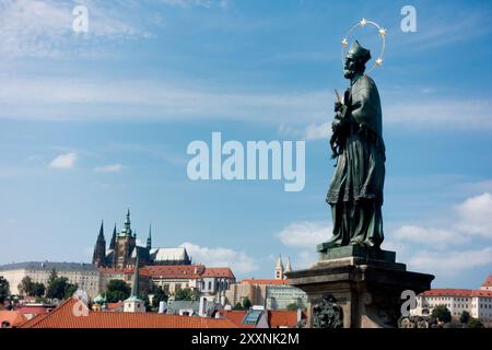Heiliger Ort, Statue des heiligen Johannes von Nepomuk auf der Karlsbrücke, mit Panorama der Prager Burg im Hintergrund, Tschechische Republik Stockfoto