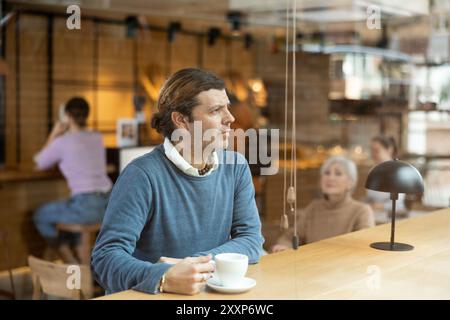 Ruhiger Mann, der Ruhe und Frieden allein in einem gemütlichen Café genießt Stockfoto