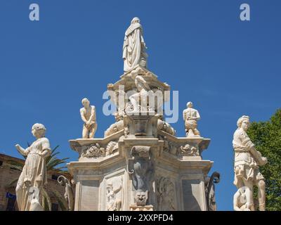 Detaillierter Blick auf einen historischen Brunnen mit mehreren Statuen unter einem klaren blauen Himmel, palermo, sizilien, mittelmeer, italien Stockfoto