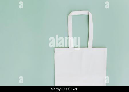 Eco weiß Handwerk Papiertasche flach lag auf grünem Hintergrund mit Kopierplatz leere Werbefläche. Modell der Verpackungsvorlage. Lieferservice, wiederverwendbar Stockfoto