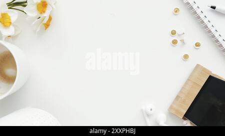 Büroarbeit, Bildung Flat Lay Konzept mit Clips, Telefon, Ohrhörer, Tasse Kaffee und Tulpenblüten, Bleistift und Notizblock auf weißem Hintergrund. Stockfoto