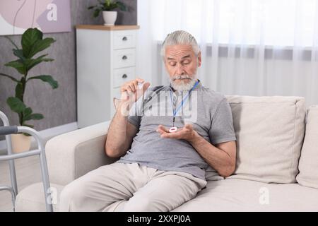 Senior Mann mit Notruftaste zu Hause Stockfoto