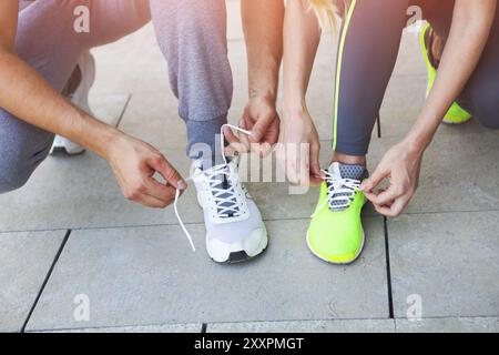 Frau und Mann schnüren vor dem Training Laufschuhe. Nahaufnahme. Fitness und gesundes Lifestyle-Konzept Stockfoto