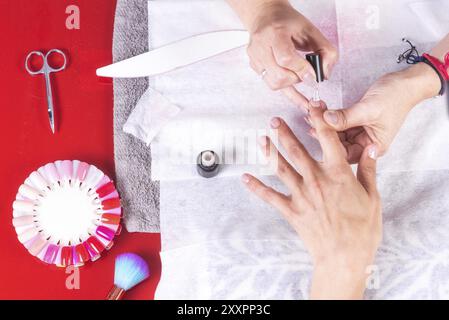 Professioneller Maniküre-Arbeitstisch mit Arbeitswerkzeugen, nagellack in einem Frauennägel-Salon auftragen Stockfoto