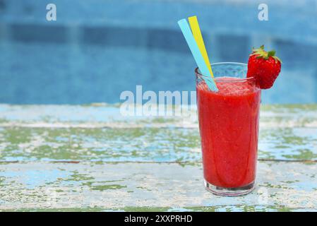 Erdbeer Smoothie auf alten Rusric blauem Hintergrund in der Nähe von Schwimmbad Stockfoto