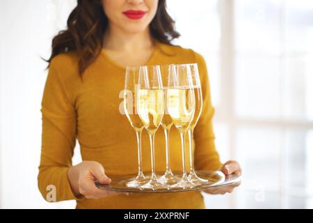 Junge Frau mit Champagner Gläser auf dem Fach Stockfoto