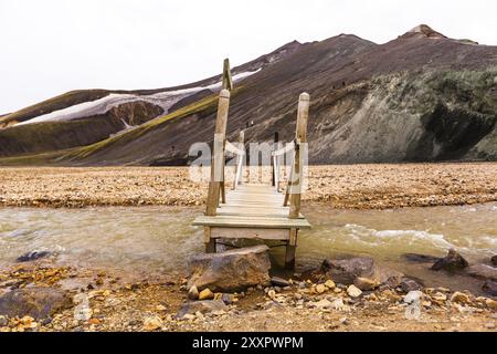 Kleine Holzbrücke, die über einen kleinen Bach in Landmannalaugar auf Island führt Stockfoto