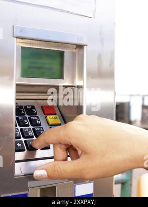 Frau, die die PIN an einem Kartenautomat eingibt Stockfoto