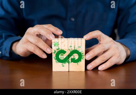 Circular Economy-Konzept, mit Hand haltender Holzwürfelblock mit Circular Economy-Symbol und Kopierraum. Symbol für Endlosschleife. Stockfoto