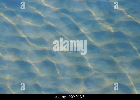 Lichtreflexe der Sonne durch die Wellen in flachen Gewässern Stockfoto