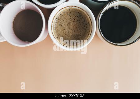 Mehrere Kaffeetassen auf beigefarbenem Hintergrund. Stockfoto