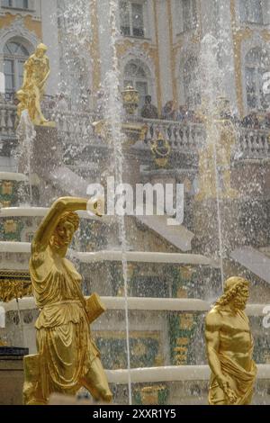 Herrlicher Brunnen mit goldenen Statuen vor einem Gebäude, Menschen und Kunst im Hintergrund, sankt petersburg, ostsee, russland Stockfoto