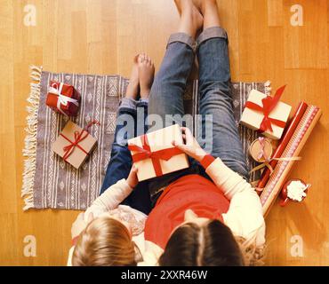 Fröhliche Mamma und ihre süße Tochter Mädchen ihre Weihnachtsgeschenke austauschen. Ansicht von oben Stockfoto