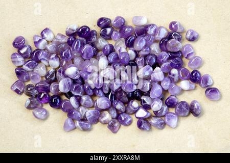 Set aus verschiedenen natürlichen Amethyst-Mineralsteinen und Edelsteinen auf grauem Stoffhintergrund, teilweise fokussiert von oben Stockfoto